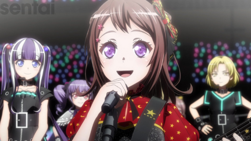BanG Dream! S2’s Kasumi holds a microphone to her mouth, grinning as she addresses a huge crowd. She has large purple eyes and wears a red dress patterned with stars.